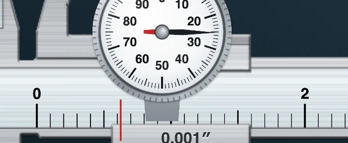 Zoomed dial caliper face with the needle on division 25 and the graduated beam below it